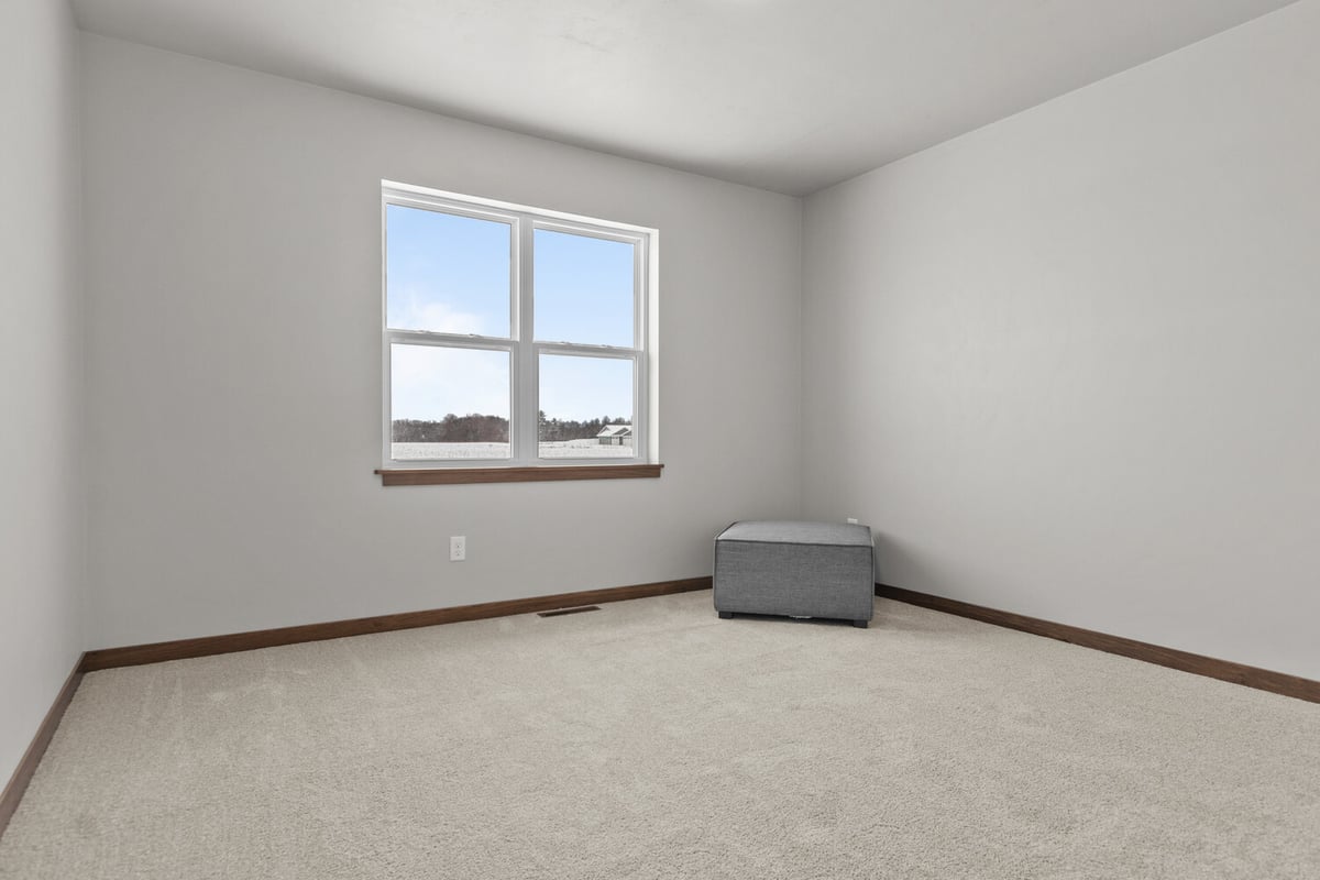 Windowed bedroom showcasing snowy exterior in custom home by Midwest Design Homes in WI