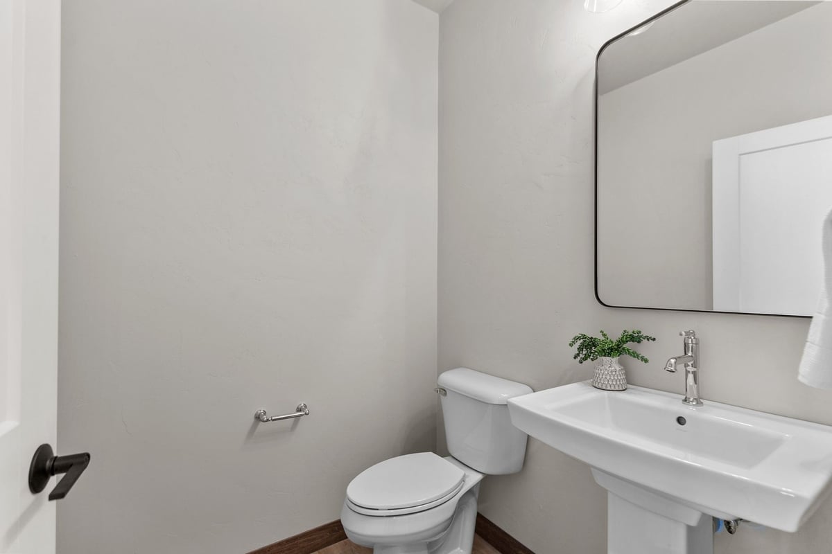 Compact powder room with mirror in Midwest Design Homes custom build, Wisconsin