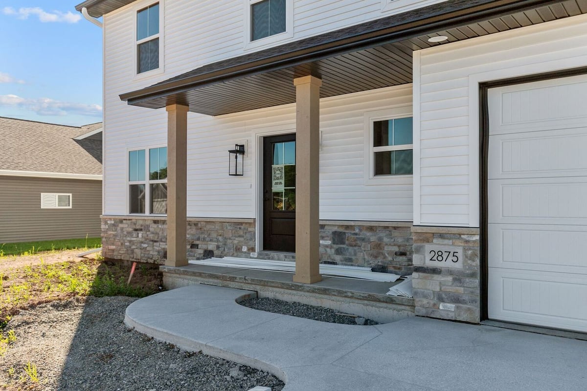 Covered front porch with stone columns in Midwest Design Homes custom home, Wisconsin