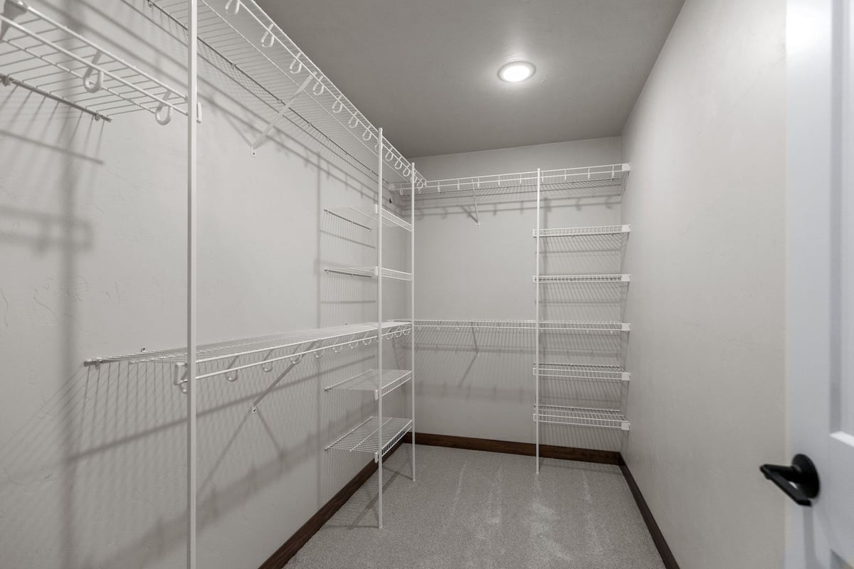 Large walk-in closet with shelves in Wisconsin home by Midwest Design Homes