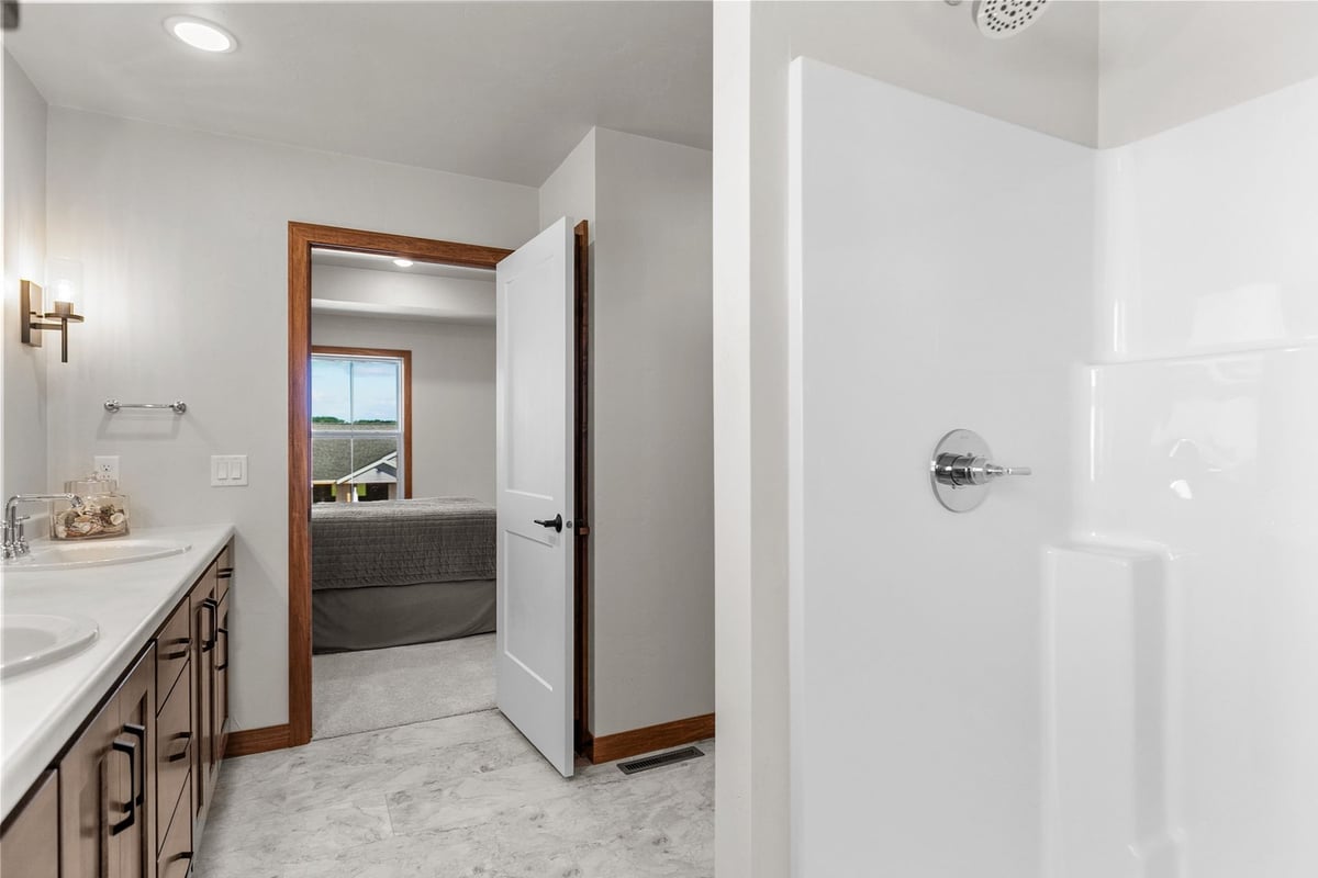 Master bath with shower and wood cabinets in custom Wisconsin home by Midwest Design Homes