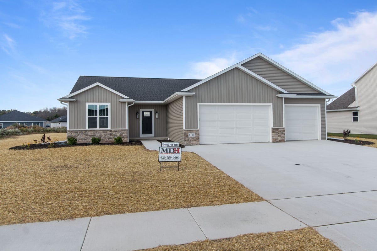 Custom home with three-car garage and MDH sign in Kaukauna, WI