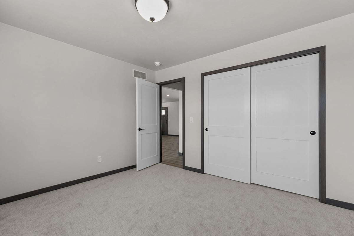Bedroom with white closet doors by Midwest Design Homes in De Pere and Neenah, WI