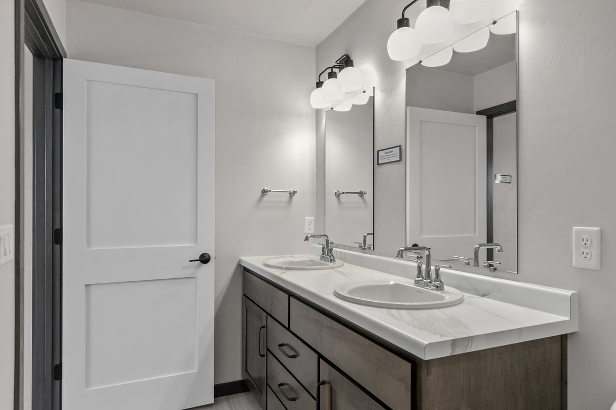 Double vanity with wood cabinets in WI bathroom by Midwest Design Homes