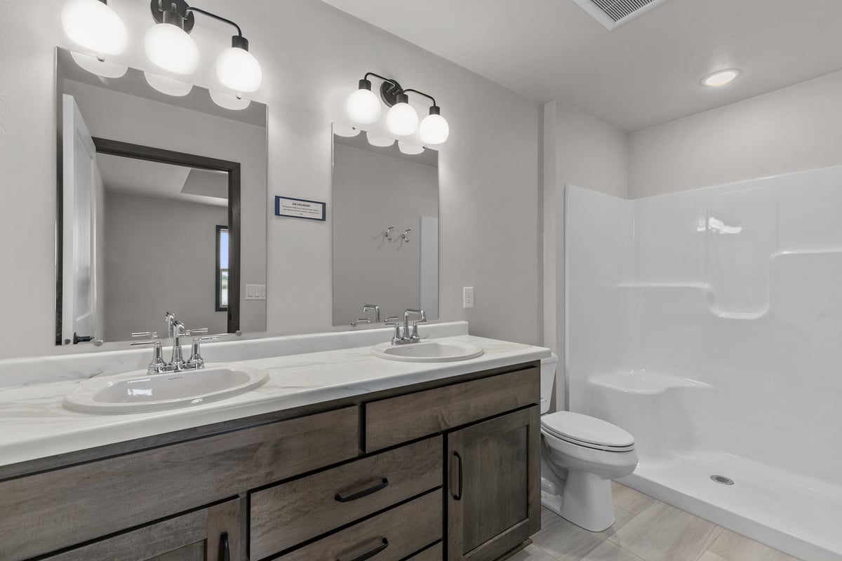 Full bathroom with shower, vanity and toilet in WI home by Midwest Design Homes