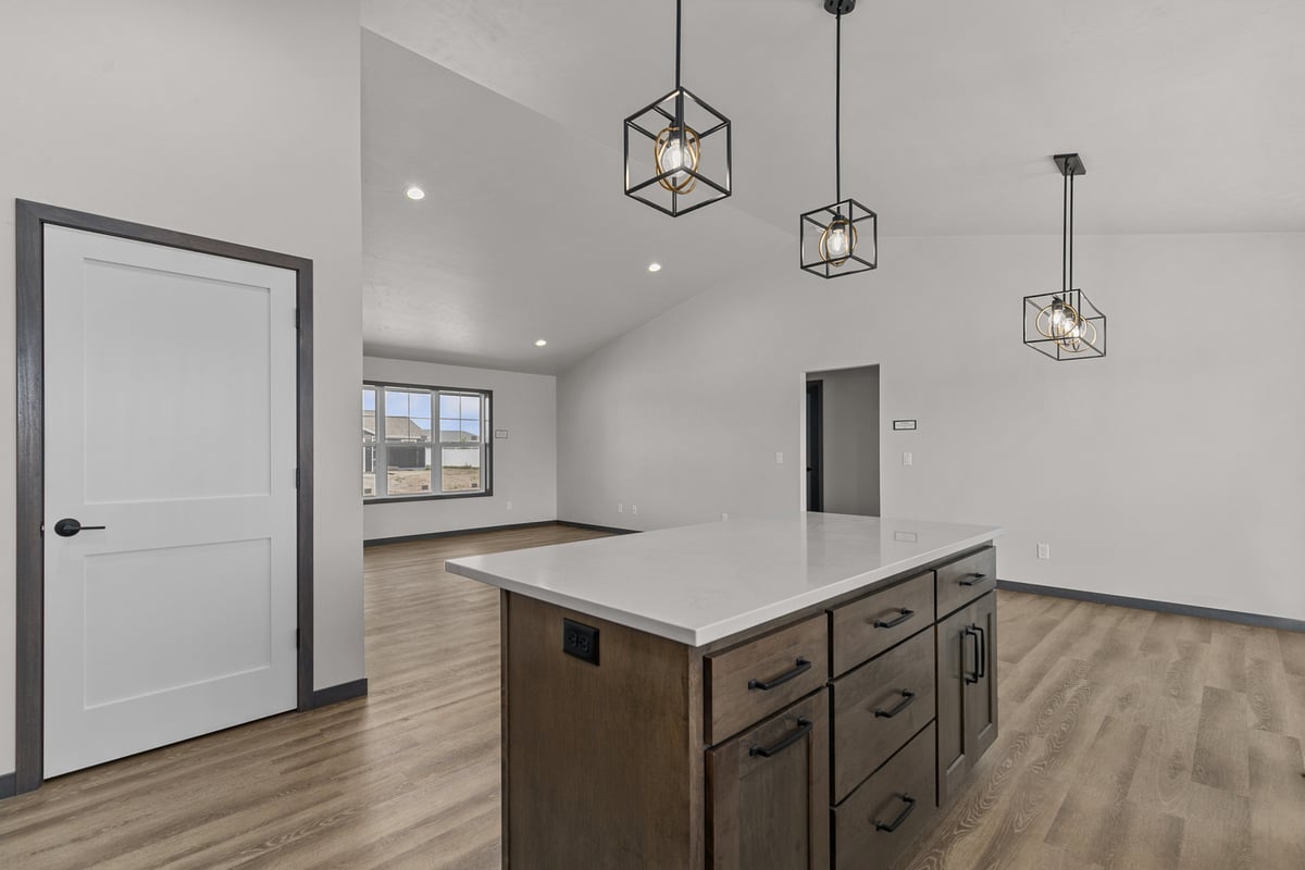 Kitchen island lighting and living area in Kaukauna, WI by Midwest Design Homes