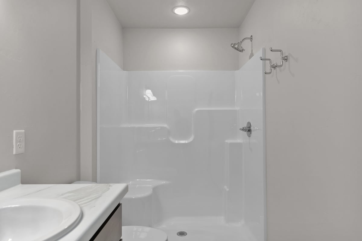 Simple white fiberglass shower in WI custom home by Midwest Design Homes