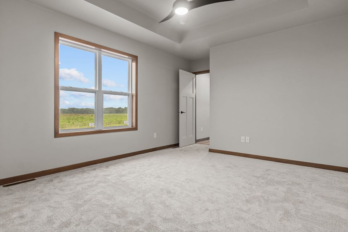 Carpeted bedroom with large window in custom home by Midwest Design Homes in Kaukauna, WI