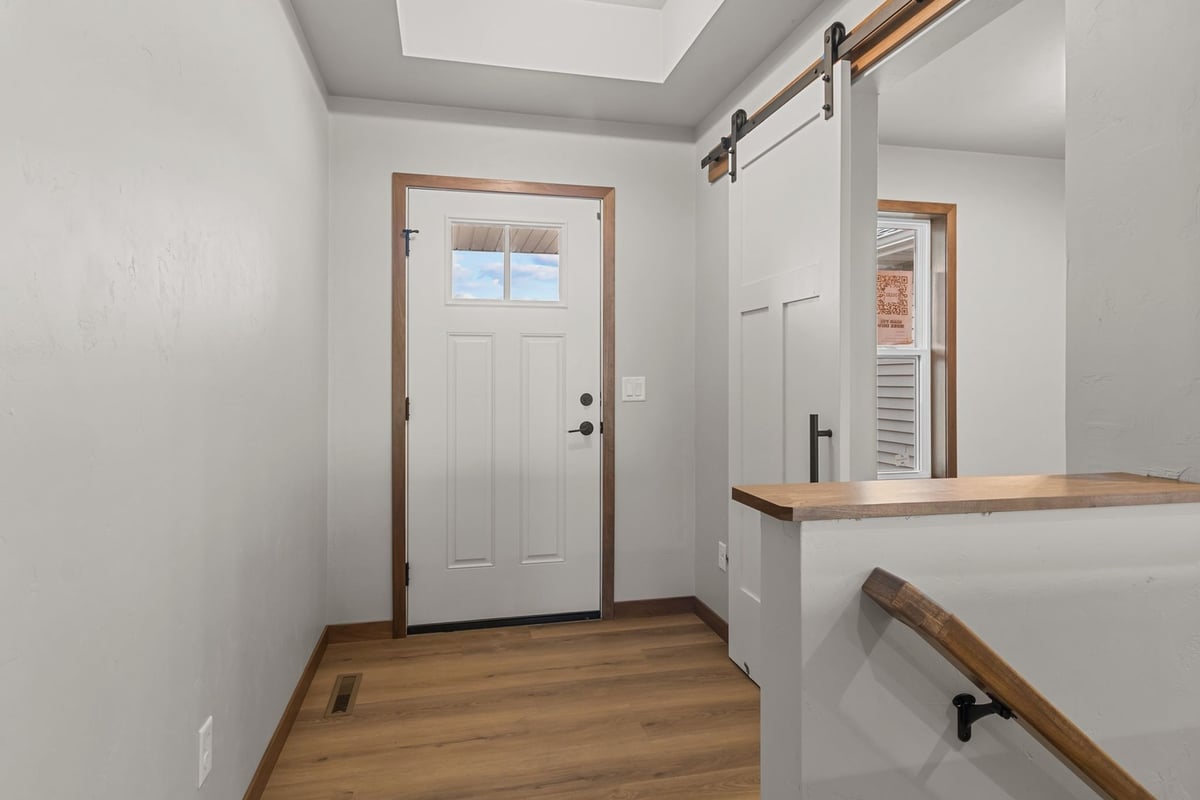 Custom home entry with barn door by Midwest Design Homes in Neenah, Wisconsin