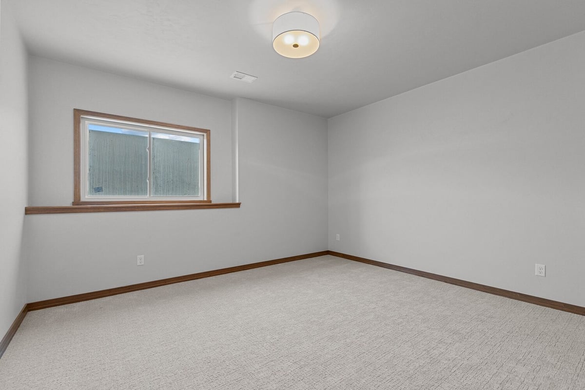 Carpeted basement bedroom with egress window by Midwest Design Homes in WI