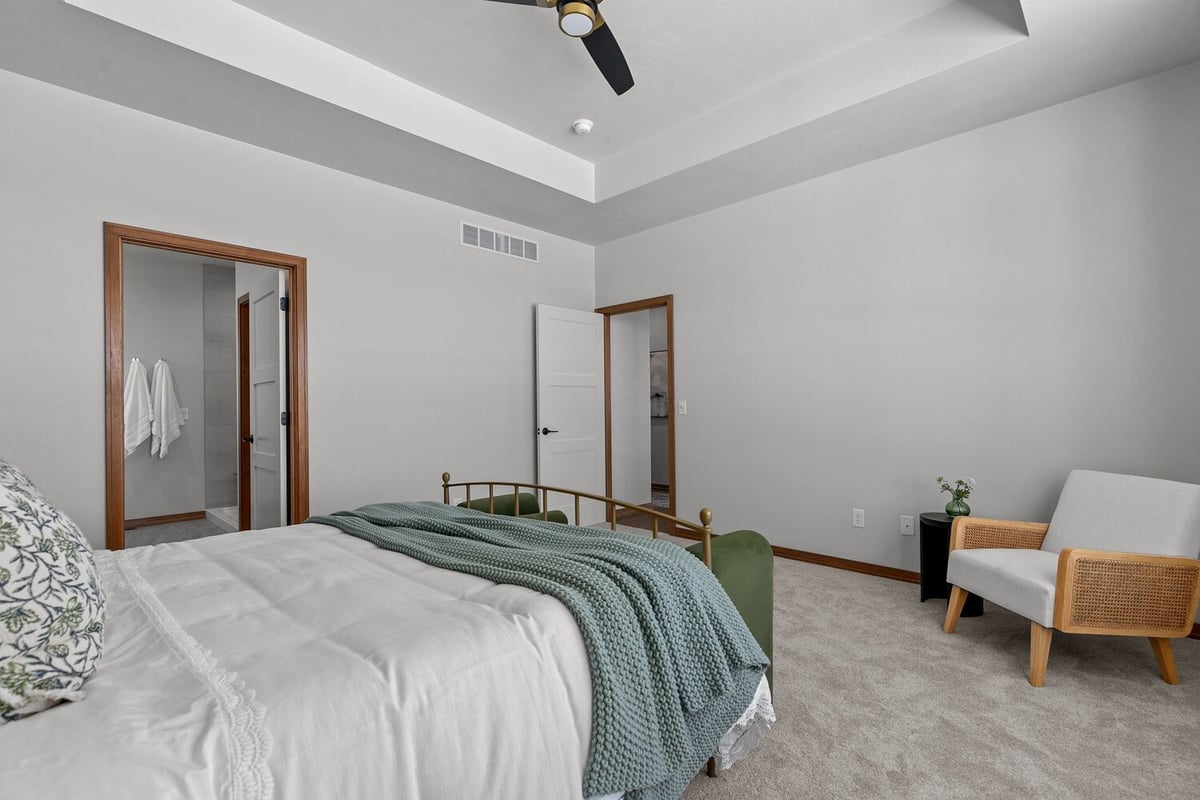 Custom bedroom with tray ceiling and open doorway in Neenah WI by Midwest Design Homes