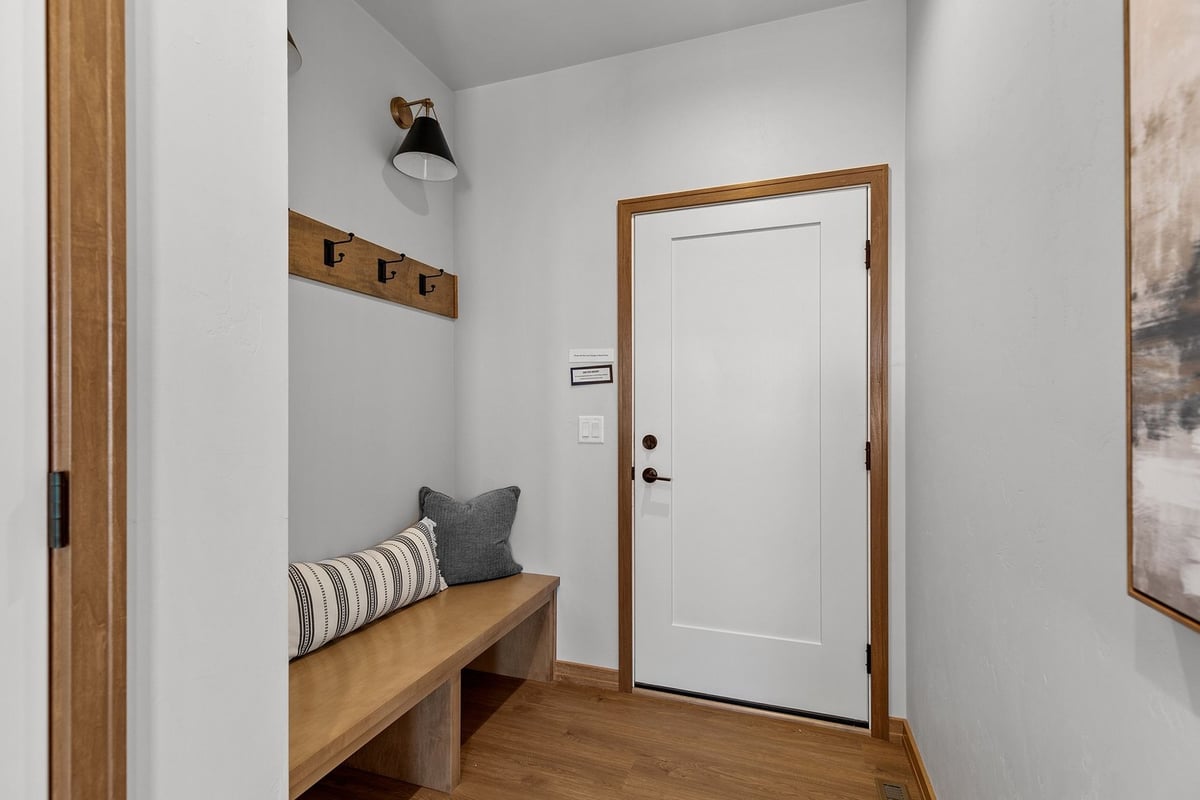 Custom home mudroom with bench and coat hooks by Midwest Design Homes in Kaukauna WI