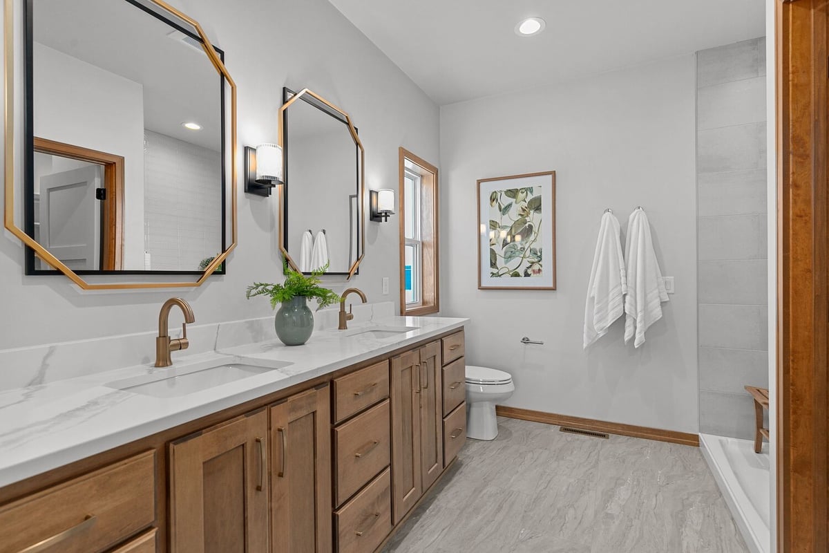 Double vanity bathroom with wood cabinets in custom home by Midwest Design Homes WI