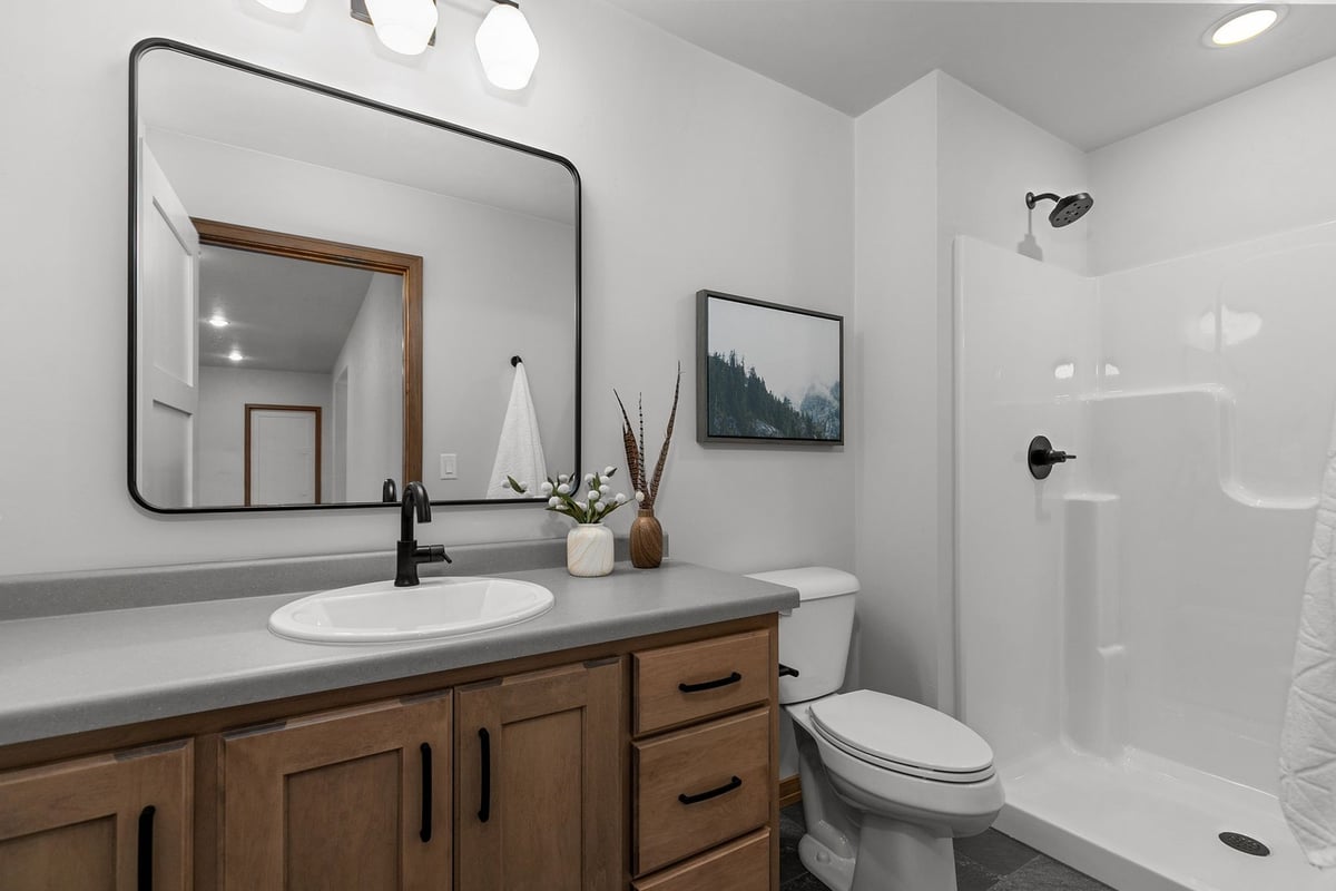 Lower-level bathroom with black fixtures by Midwest Design Homes in Appleton WI