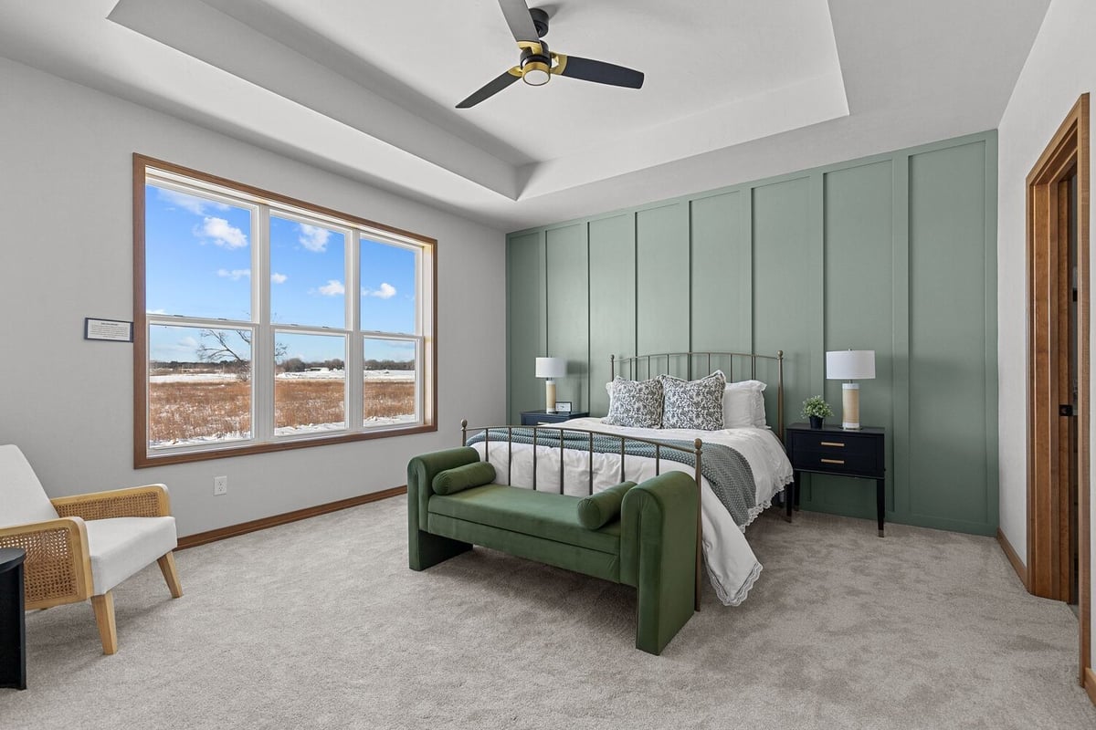 Primary bedroom with green accent wall in Wisconsin custom home by Midwest Design Homes