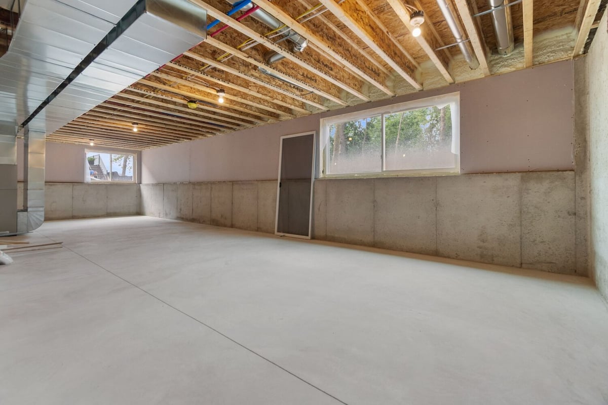 Unfinished basement with exposed joists in custom WI home by Midwest Design Homes
