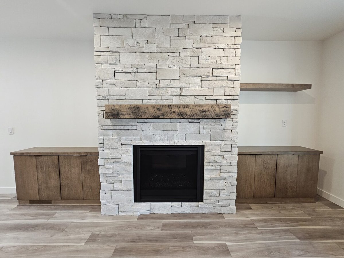 Stone fireplace with wood mantle in custom home by Midwest Design Homes in Green Bay, WI