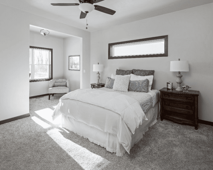 Bright bedroom with neutral decor, carpet and large windows in a Northeast Wisconsin home