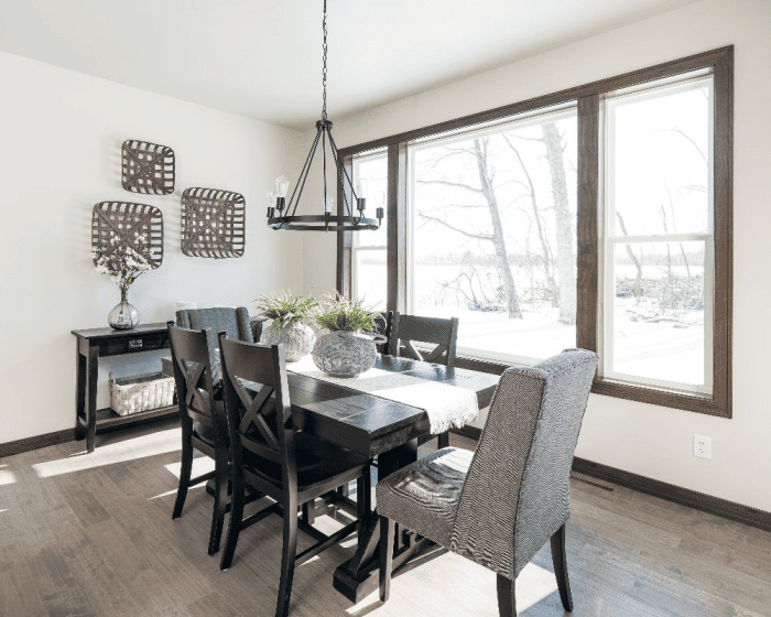Dining area with dark wood table, large windows and snowy views in a Northeast Wisconsin home