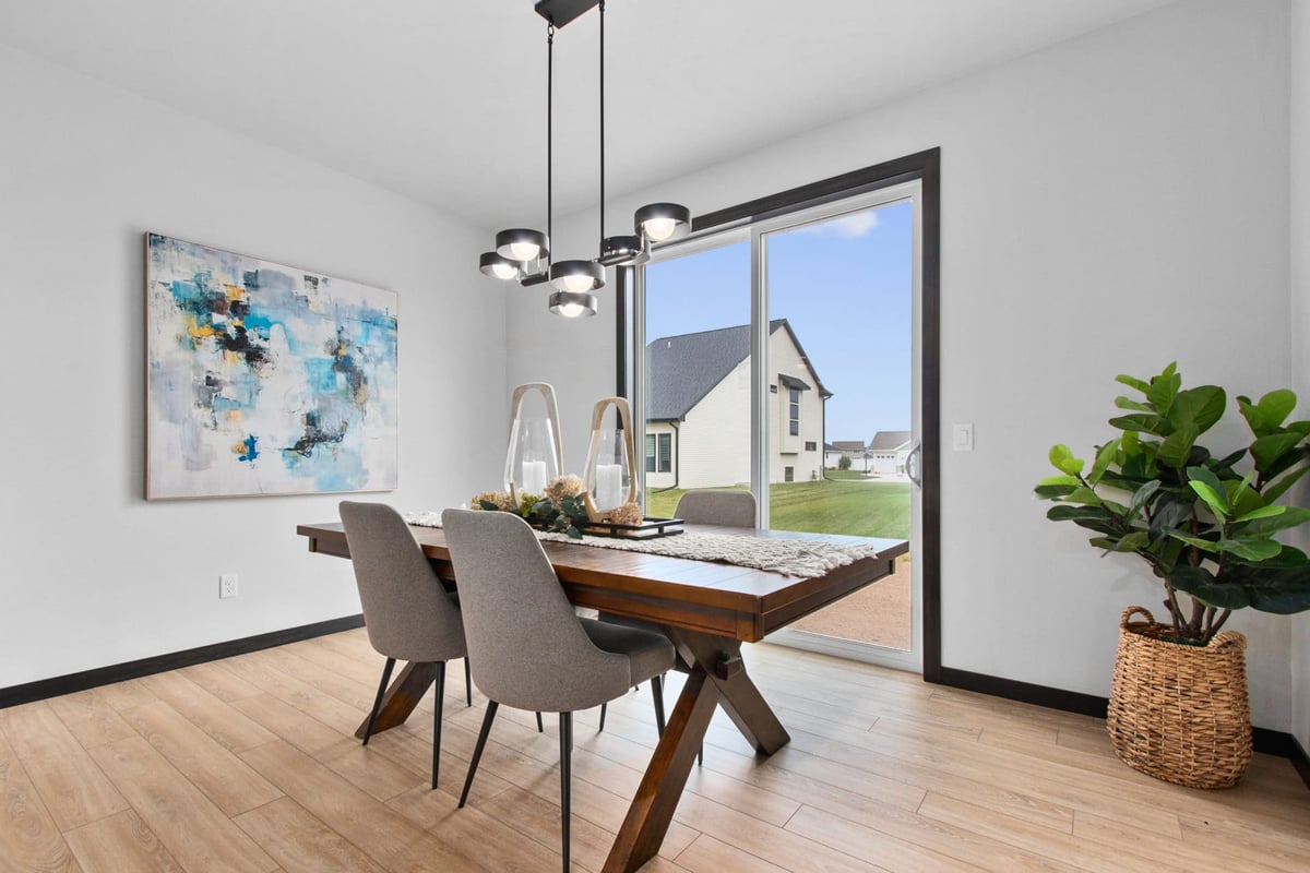 Dining area with wood table, upholstered chairs and large window in a Northeast Wisconsin home