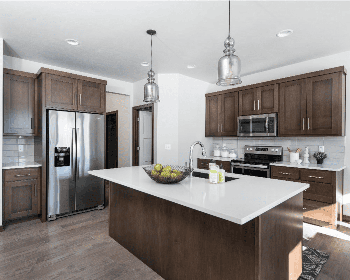 Kitchen with dark wood cabinets, white island and stainless steel appliances in a Northeast Wisconsin home