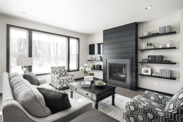 Living room with black fireplace, floating shelves and large windows in a Northeast Wisconsin home Living room with black fireplace, floating shelves and large windows in a Northeast Wisconsin home