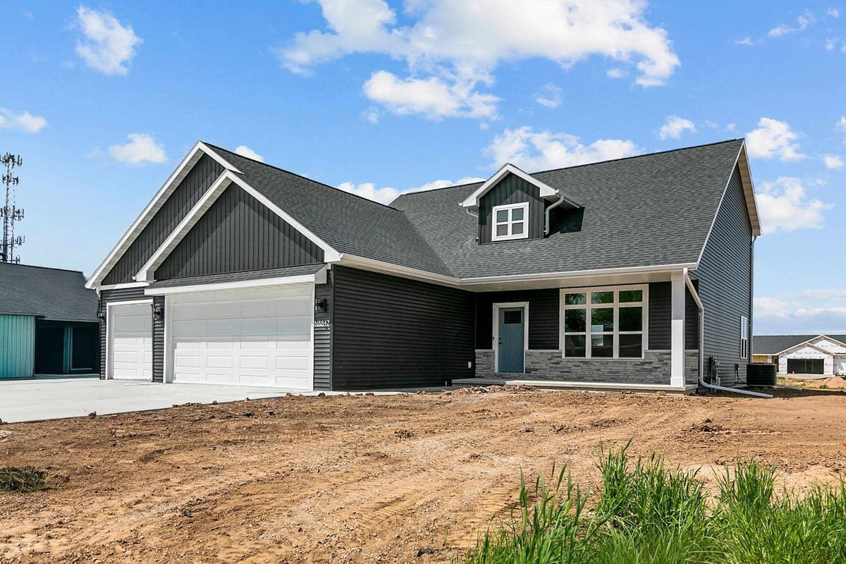 Angled front view of modern black home with covered porch in a new Appleton, WI neighborhood
