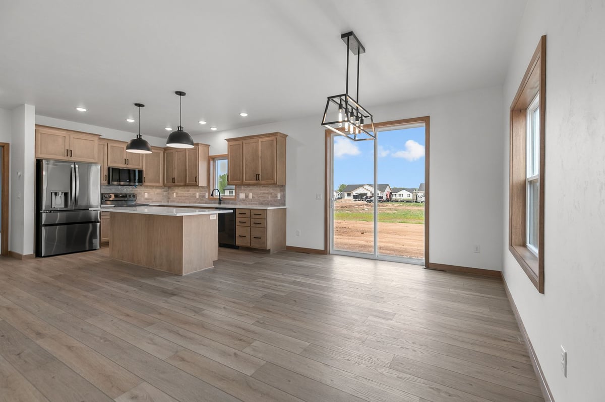 Bright dining area and kitchen with island seating in a new Appleton, WI home