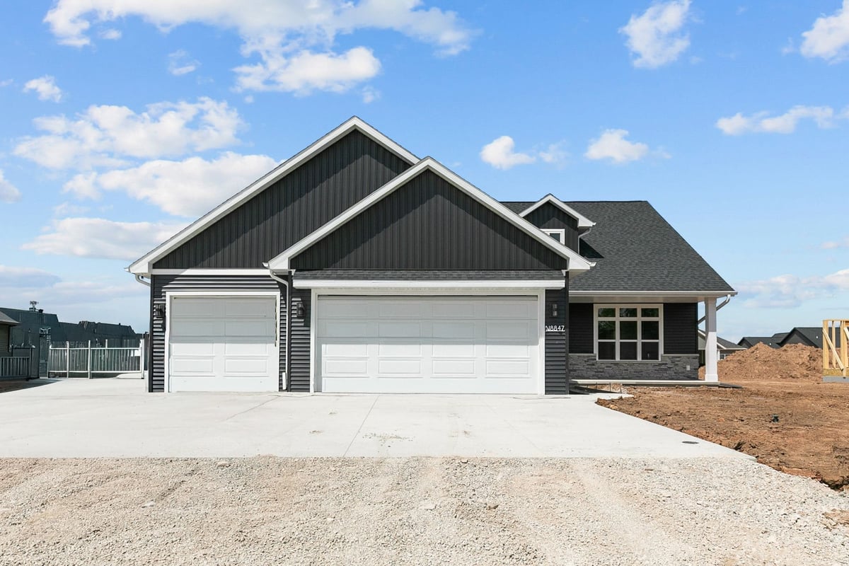 Front exterior of modern black home with three-car garage and wide driveway in Appleton, WI