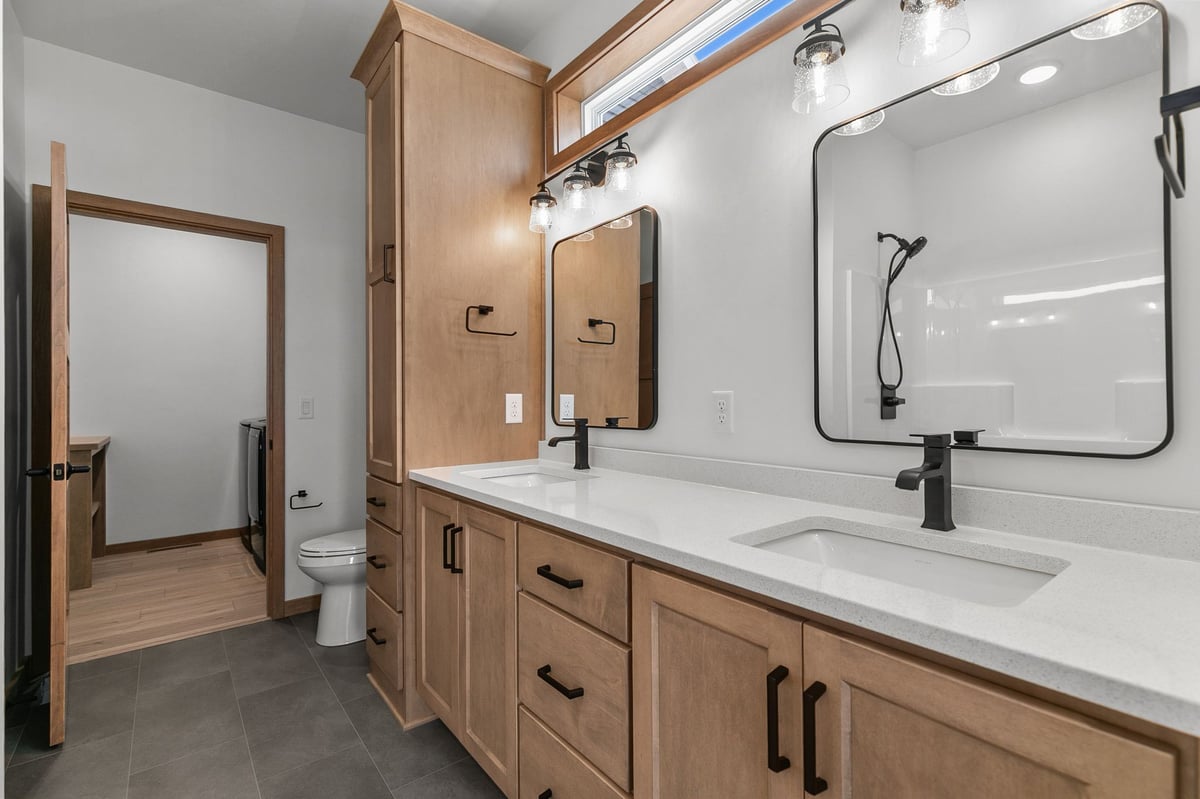 Modern bathroom with double vanity, wood cabinets, and walk-in shower in Appleton, WI