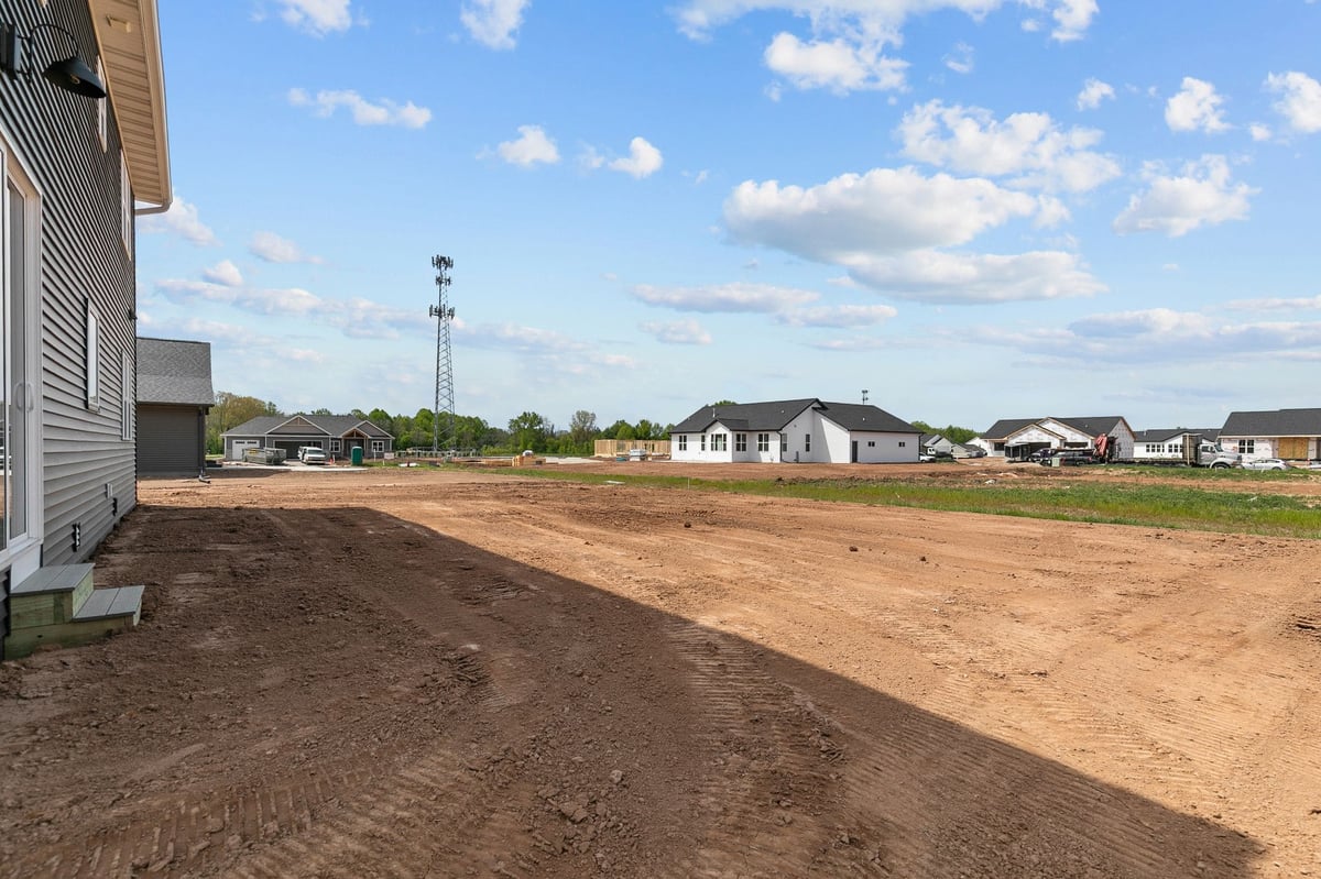 Spacious backyard view with new construction homes and open lots in Appleton, WI neighborhood