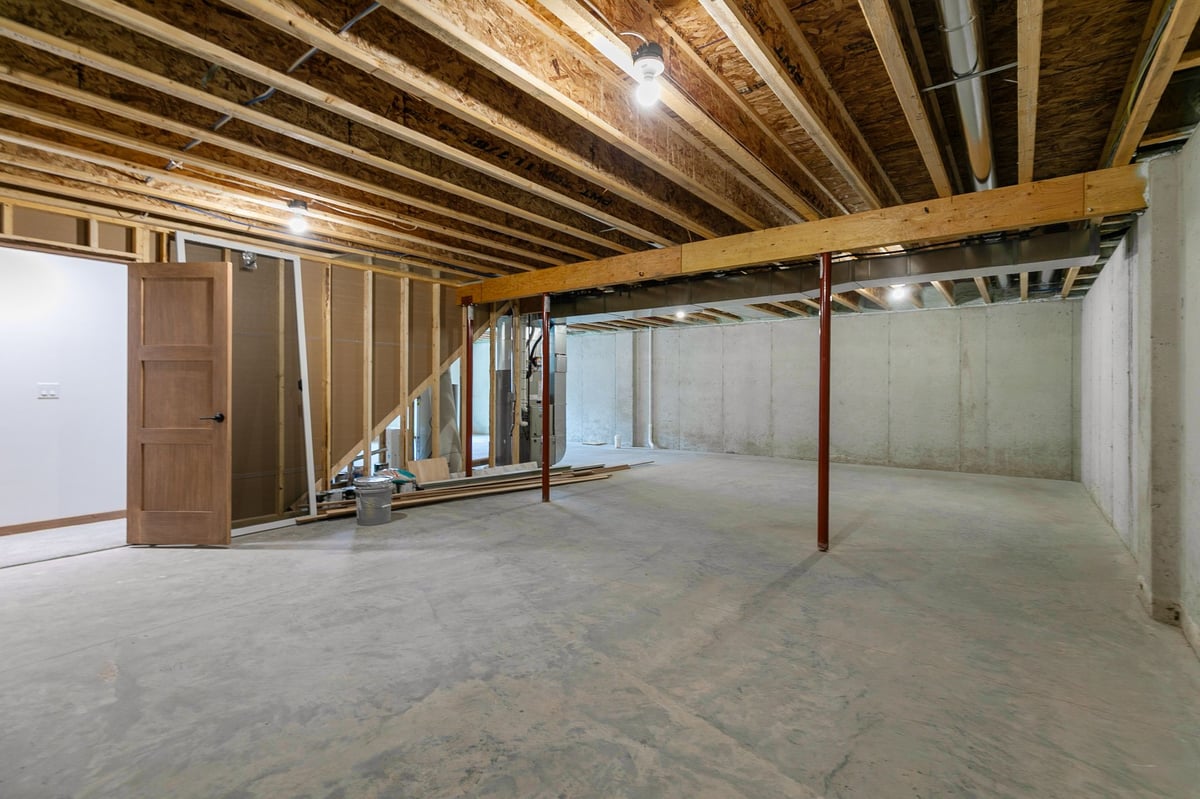 Unfinished basement with open layout and exposed beams in a new Appleton, WI construction home