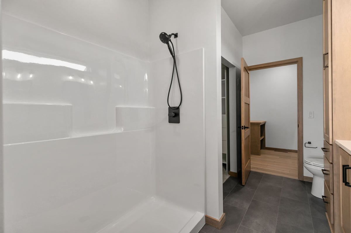Walk-in shower with black fixtures and modern bathroom finishes in Appleton, WI