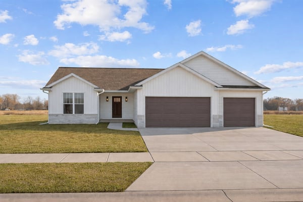 New single-story home in the Fox Cities with white siding, three-car garage, fresh driveway, and blue sky-1