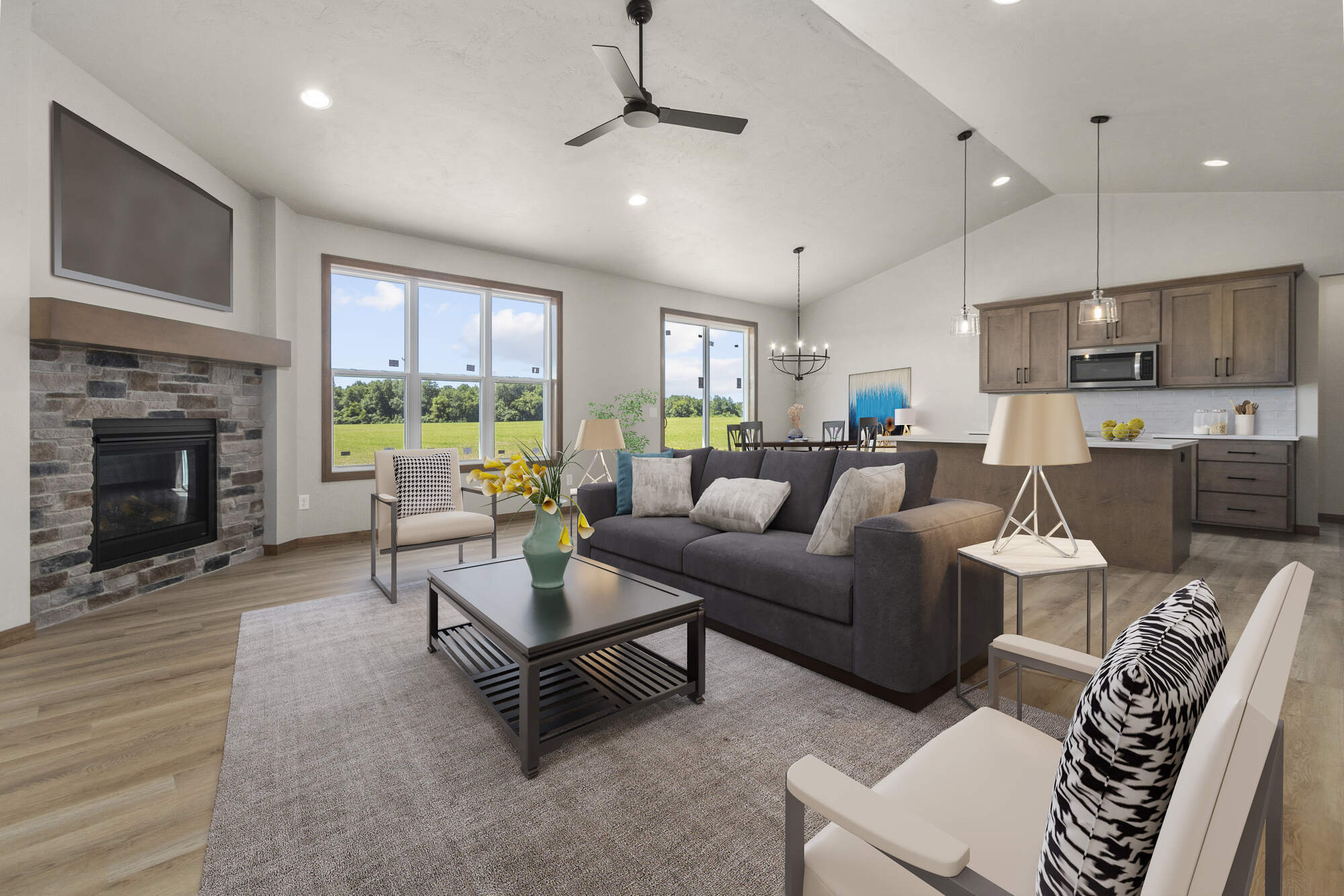 Staged living and dining space with kitchen island and large windows by Midwest Design Homes