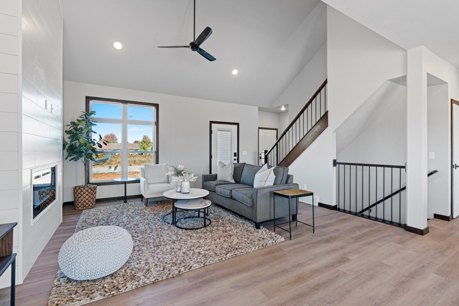 Spacious living area with stairway and modern decor in a custom-built home by Midwest Design Homes in Kaukauna, WI.