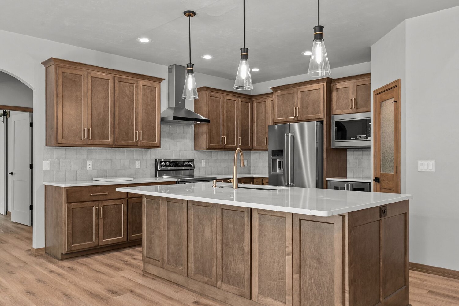 Kaukauna custom kitchen by Midwest Design Homes with pendant lights and tile backsplash