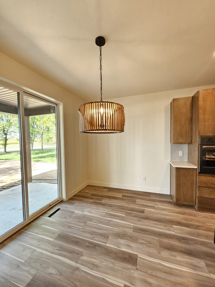 Custom dining space with wood flooring and pendant light in Kaukauna by Midwest Design Homes Custom dining space with wood flooring and pendant light in Kaukauna by Midwest Design Homes