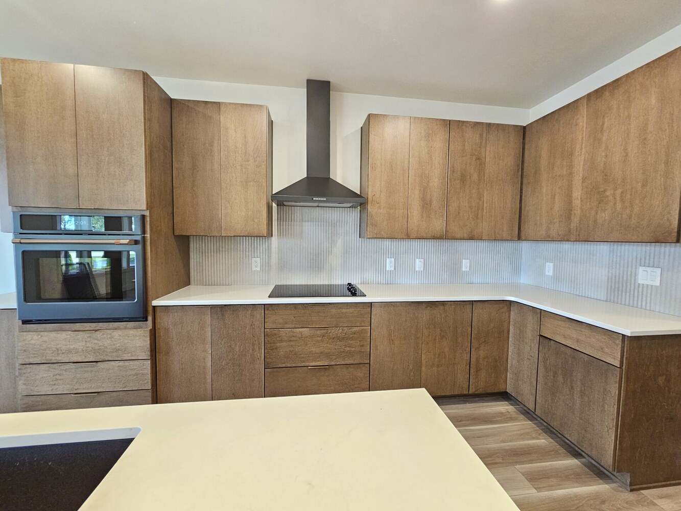 Custom kitchen with natural wood cabinets and range hood by Midwest Design Homes in Kaukauna