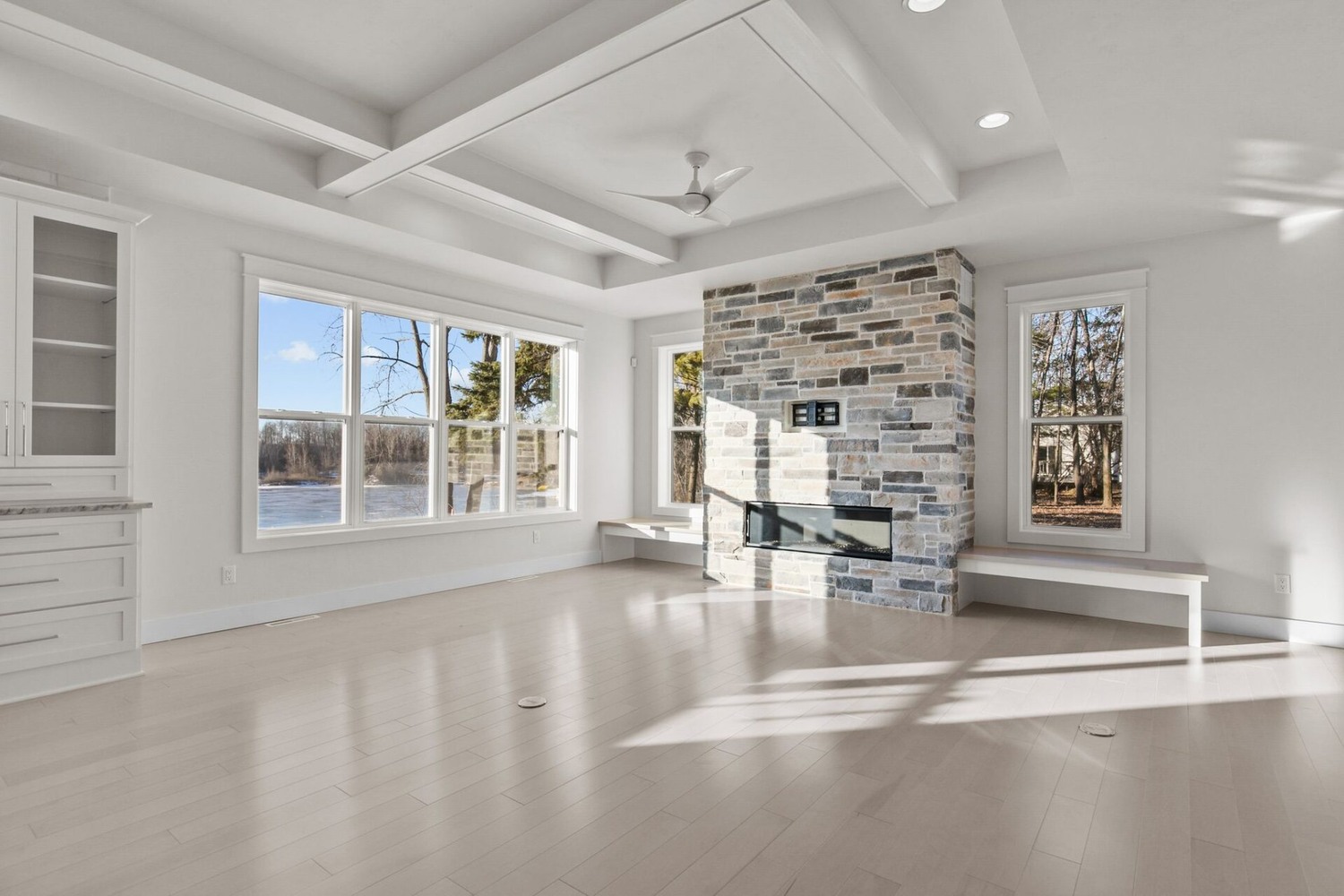 Stone fireplace and lake view windows in Neenah custom home by Midwest Design Homes